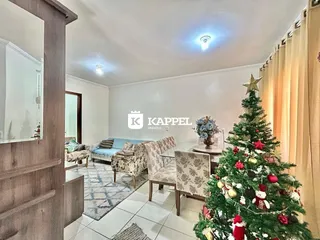 Sala de estar com sofá e árvore de Natal decorada.