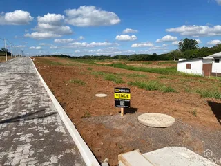 Vista externa de uma área de terreno aberto com estrada no primeiro plano.