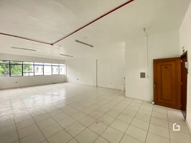 Ambiente interno de uma sala ampla com piso de cerâmica clara.