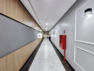 Corredor interno com piso de mármore e painéis de madeira.