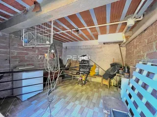 Interior de um espaço com paredes de tijolo aparente e teto de madeira.