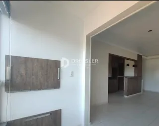 Vista interna de um corredor com paredes brancas e uma abertura para outro cômodo.