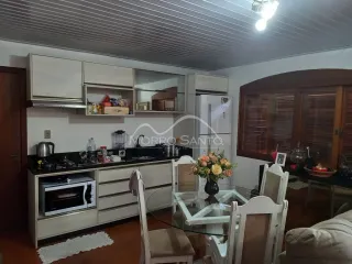 Cozinha com armários brancos e bancada escura em ambiente interno.