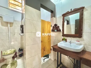 Banheiro com revestimento de azulejos e bancada de madeira.