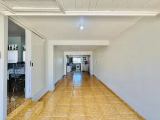Corredor interno com piso de cerâmica de cor amarela.