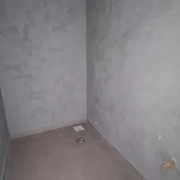 Vista interna de um corredor com paredes claras e piso neutro.