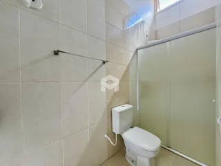 Foto de um banheiro com revestimento de cerâmica e box de vidro.