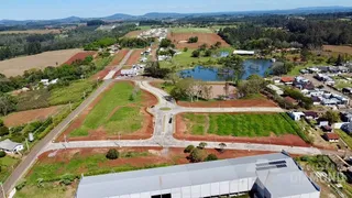 Vista aérea de uma propriedade rural com áreas verdes e um corpo d'água.