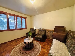 Sala de estar com piso de madeira e grandes janelas.