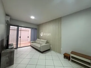 Sala de estar com piso de cerâmica branca e sofá claro.