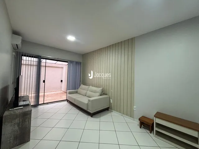 Sala de estar com piso de cerâmica branca e sofá claro.
