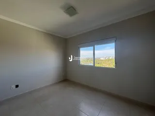 Ambiente interno de uma sala com janela de vista para a paisagem.