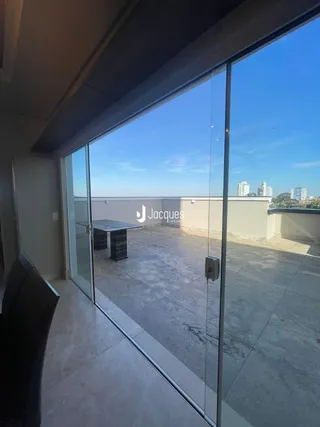Vista da sala de estar com portas de vidro que dão acesso a uma área externa.