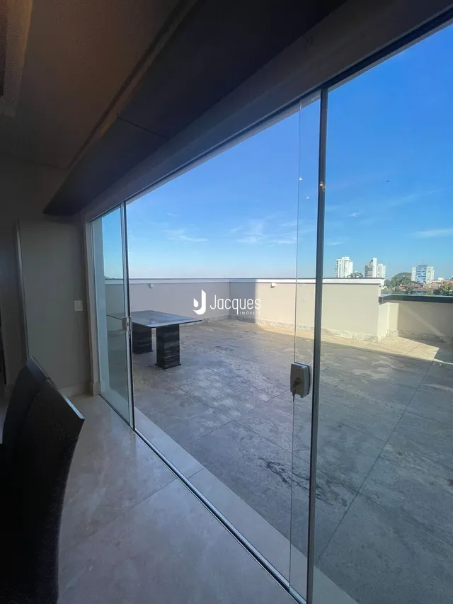 Vista da sala de estar com portas de vidro que dão acesso a uma área externa.