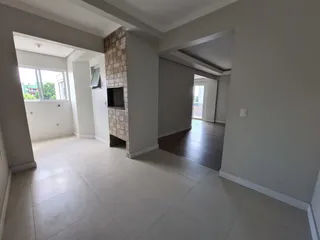 Uma foto do interior de uma sala com piso de cerâmica e coluna de tijolos aparentes.