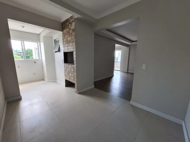 Uma foto do interior de uma sala com piso de cerâmica e coluna de tijolos aparentes.
