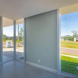 Vista de um espaço interno com grandes portas de vidro que dão acesso ao exterior.