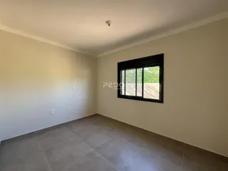 Ambiente interno de uma sala com piso de cerâmica e janela grande.
