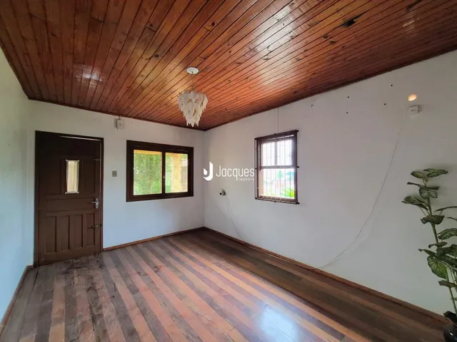 Ambiente interno com piso de madeira e teto de madeira em uma residência.