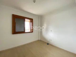 Interior de um cômodo com piso de madeira clara e paredes brancas.