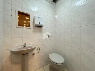 A foto mostra o interior de um banheiro com azulejos brancos.