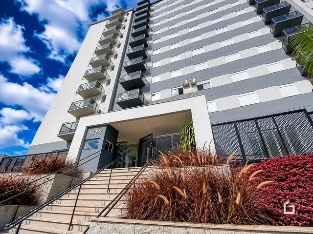 Fachada de um prédio residencial em Lajeado, Brasil com terraços e jardim na frente.