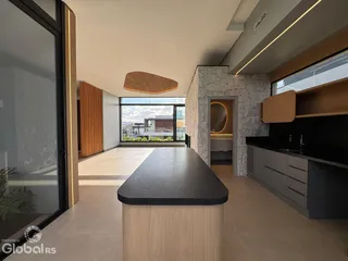 Vista de uma cozinha moderna com ilha e grandes janelas em Lajeado.