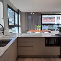 Foto de uma cozinha com armários e bancada clara em um imóvel.