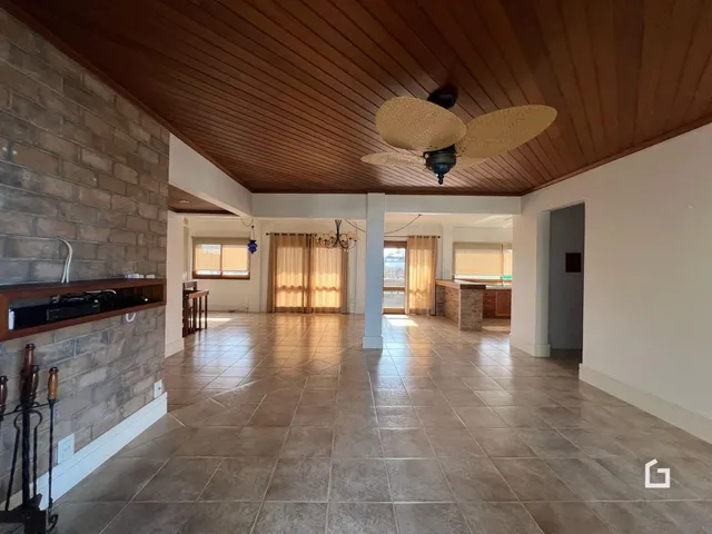Interior de uma sala de estar com piso de cerâmica e teto de madeira.