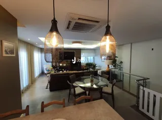 Sala de estar com piso de madeira e grandes janelas.