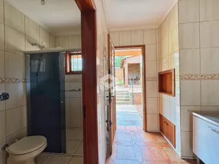 Hall de corredor interno com revestimento de cerâmica e porta de entrada para o exterior.