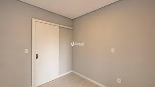 Vista de um corredor interno com porta branca em uma residência.