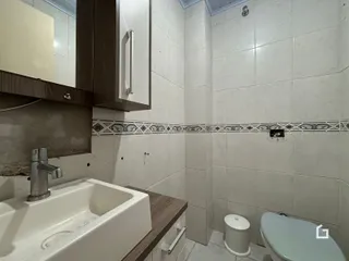 Banheiro com revestimento cerâmico nas paredes e piso.