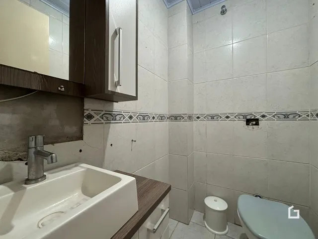 Banheiro com revestimento cerâmico nas paredes e piso.