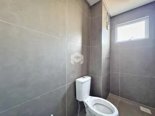 Foto de um banheiro com revestimento de cerâmica cinza.