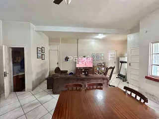 Sala de estar com móveis de madeira e piso cerâmico em um imóvel no Brasil.