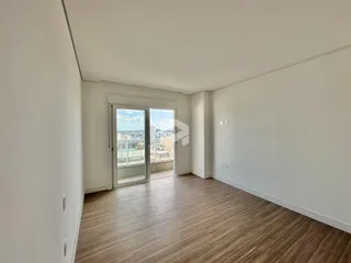 Interior de um ambiente com piso de madeira e porta de vidro que dá para uma vista.
