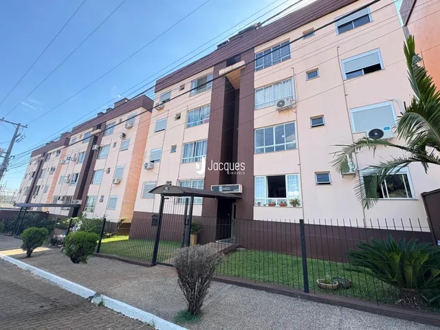 Fachada de um prédio residencial em Lajeado, Brasil, com cerca e paisagismo na frente.