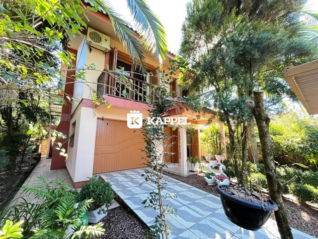 Fachada de uma residência em Lajeado, Brasil, com jardim frontal e área coberta.