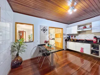Ambiente interno de uma sala de estar com piso de madeira e detalhes em madeira no teto.