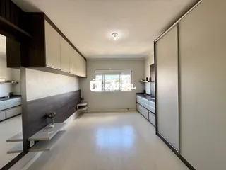 Sala de estar com armários em madeira escura e piso de madeira clara.