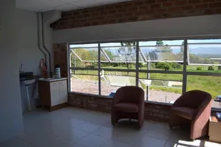Sala de estar com vista para o exterior através de grandes janelas.