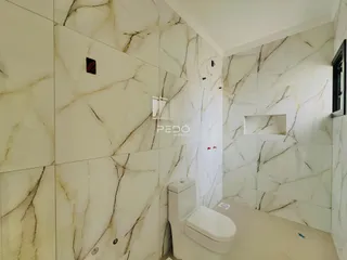 Foto de um banheiro com revestimento de mármore nas paredes.