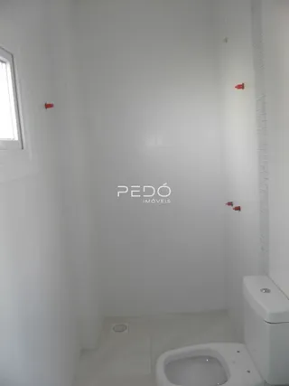 Foto de um banheiro interno com piso claro e paredes brancas.