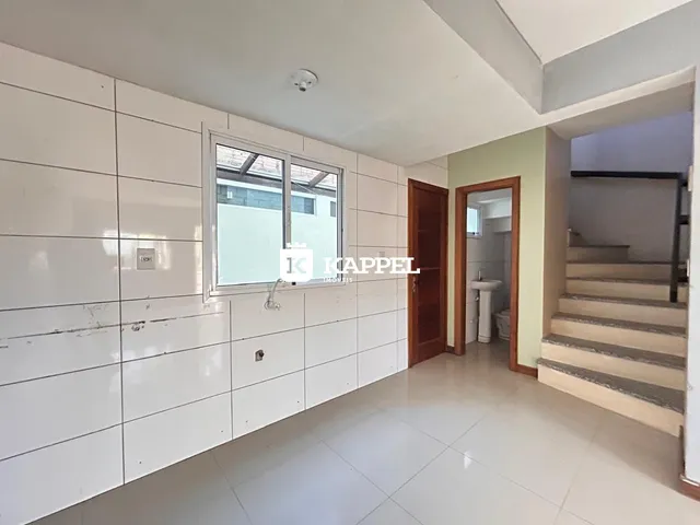 Foto de um ambiente interno com paredes brancas e piso claro.