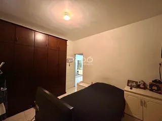 Quarto com armário de madeira e cama.