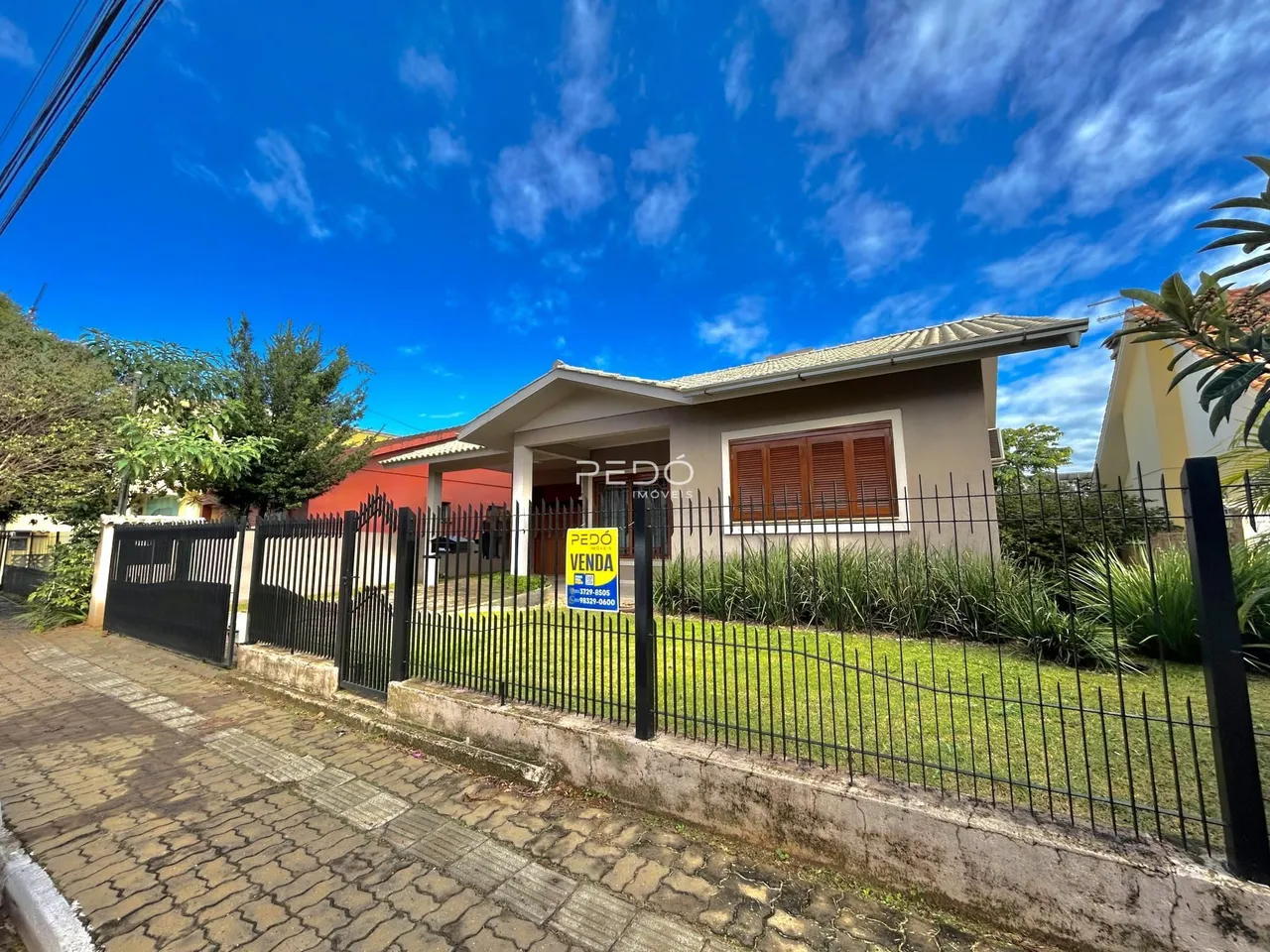 Fachada de uma residência em Lajeado, Brasil, com cerca e portão de ferro.
