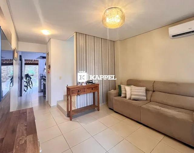 Sala de estar com sofá e cortinas claras.