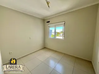 Ambiente interno de uma sala com piso de cerâmica clara e janela.