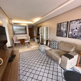 Sala de estar com sofá e piso de ladrilho claro.